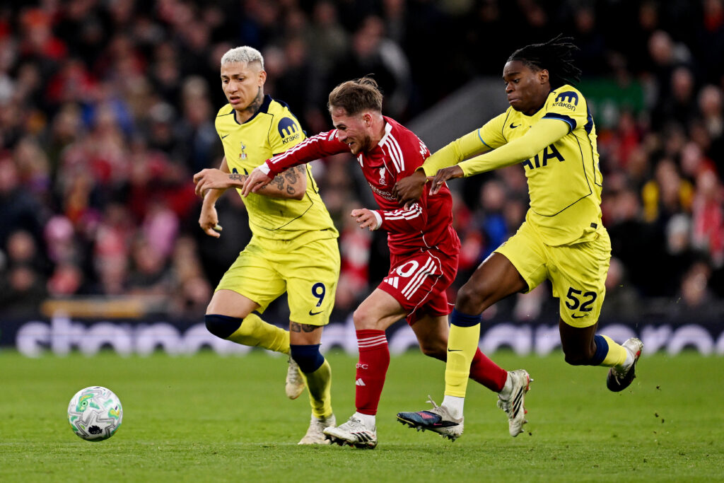 Alexis Mac Allister of Liverpool is challenged by Richarlison and Callum Olusesi of Tottenham Hotspur during the Premier League match between Liverpool and Tottenham Hotspur at Anfield.
